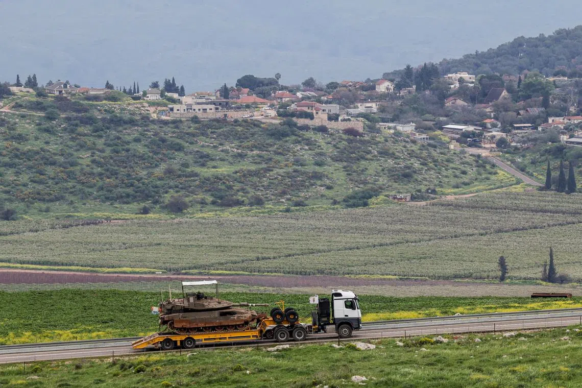 An Israeli tank is transported near the Israeli side of the border with Lebanon, amid escalating hostilities between Israel and Hezbollah, as the U.S.-Israeli conflict with Iran continues, in northern Israel, March 26, 2026. REUTERS/Tyrone Siu