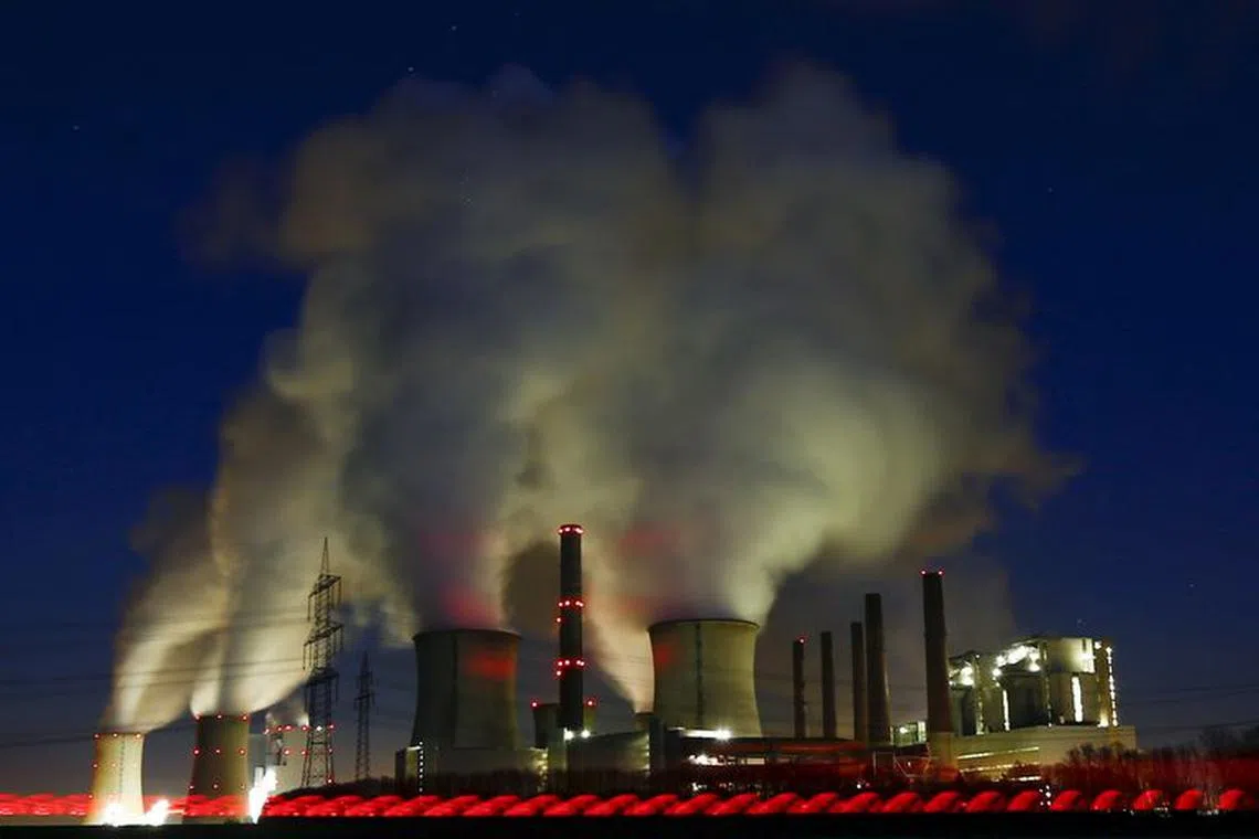 Steam rises from the chimneys of the coal power plant of RWE Power, one of Europe's biggest electricity and gas companies in Neurath, north-west of Cologne, Germany, March 3, 2016.  The red line in front of the image comes from a car driving by.    REUTERS/Wolfgang Rattay/File Photo