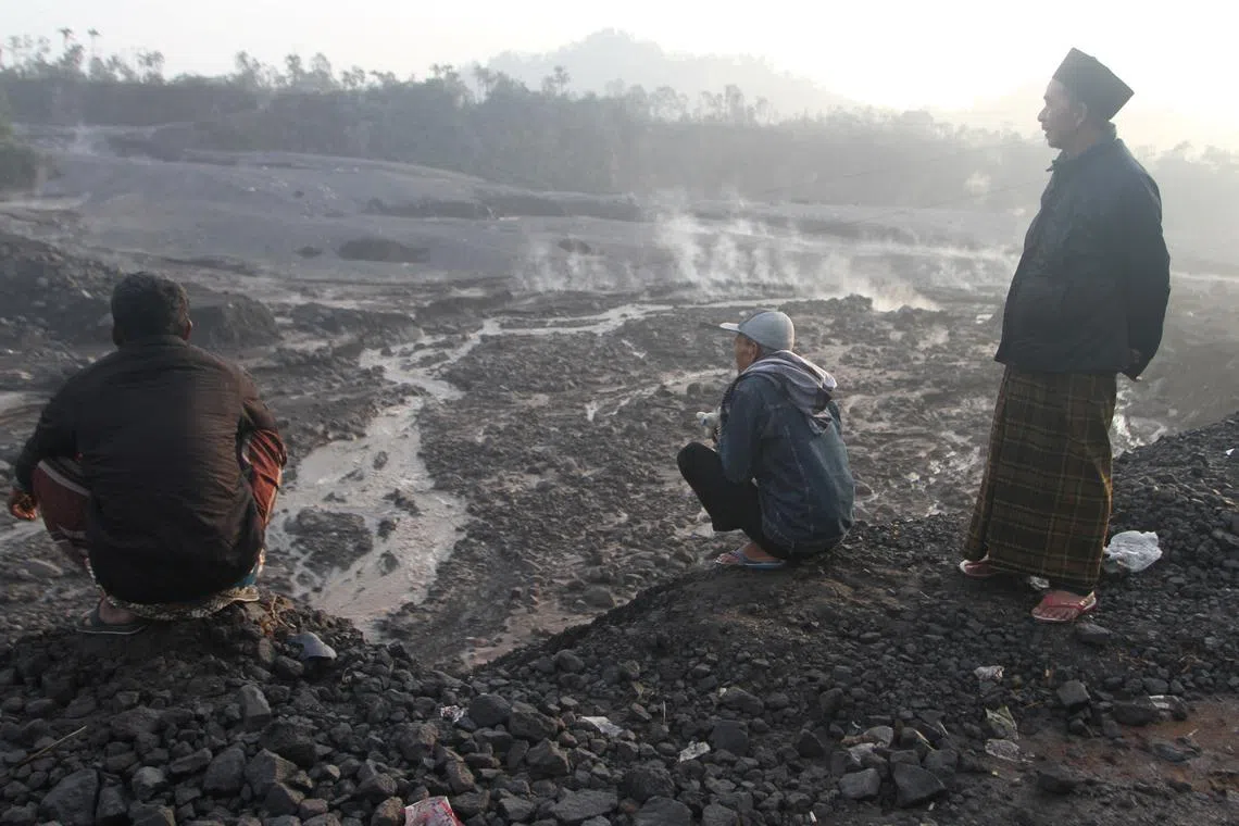 Villagers look on the volcanic material following the eruption of Mount Semeru volcano in Pronojiwo, Lumajang, East Java province, Indonesia, Dec 5, 2022, in this photo taken by Antara Foto. 