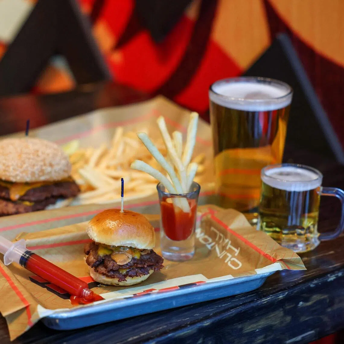 A mini burger, mini fries and mini beer, Clinton Hall’s "Teeny Weeny Mini Meal”, is pictured next to a regular-sized combo on Dec 8, 2025 in New York City.
