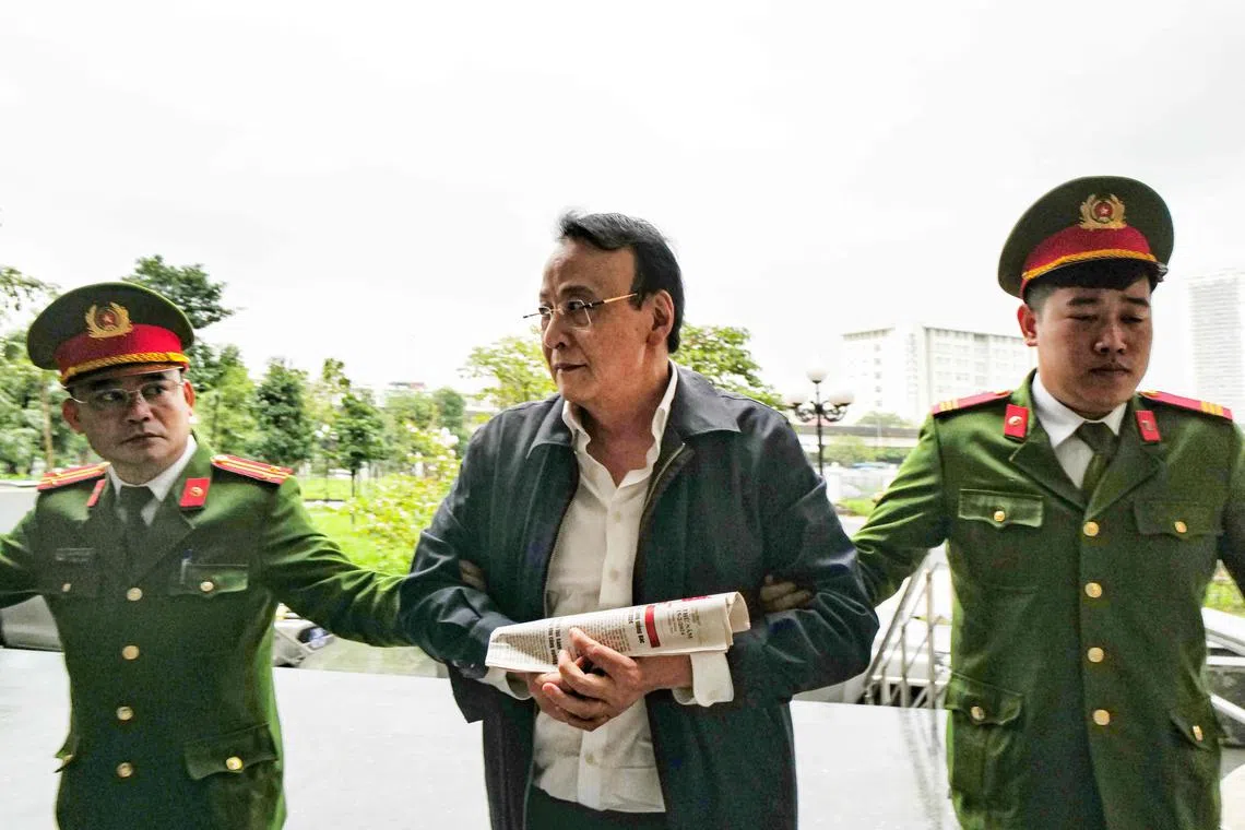 Do Anh Dung being escorted by police officers to a court for his trial on fraud charges in Hanoi on March 19, 2024.  