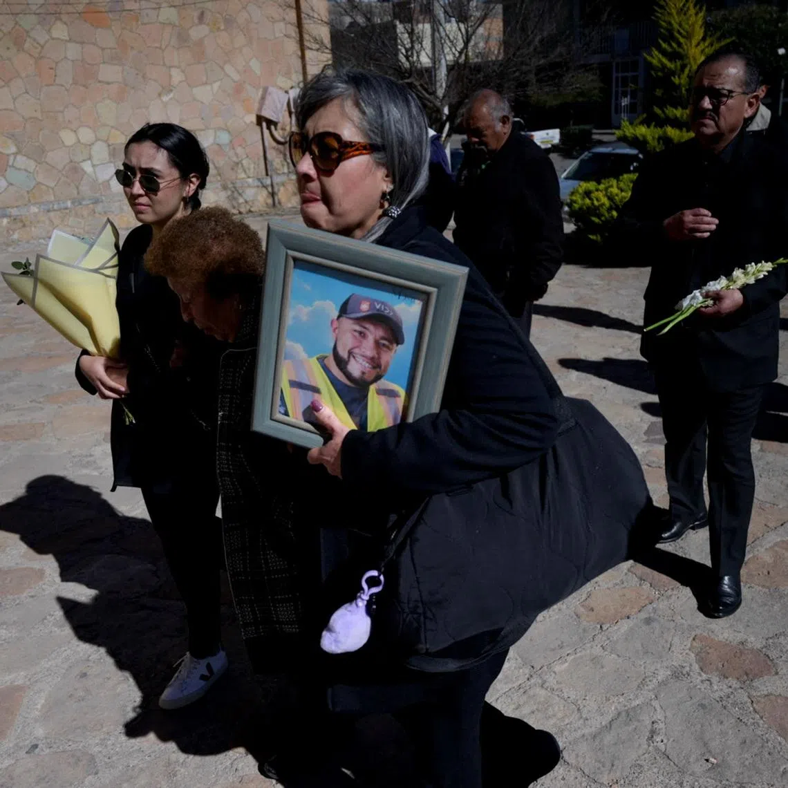 Relatives carry flowers and a framed photo of Ignacio Salazar Flores, one of the miners kidnapped from a mine run by Canada’s Vizsla Silver Corp last month and whose body was found in a clandestine grave in Concordia, Sinaloa, as they arrive at a church for a Mass, in Sombrerete, Zacatecas state, Mexico, February 10, 2026. REUTERS/Edgar Chavez