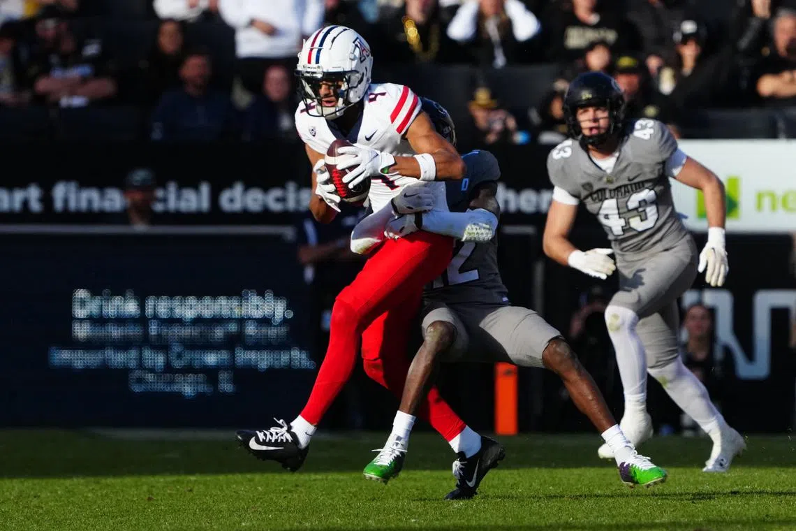 FILE PHOTO: Nov 11, 2023; Boulder, Colorado, USA; Colorado Buffaloes cornerback Travis Hunter (12) tackles Arizona Wildcats wide receiver Tetairoa McMillan (4) in the second half at Folsom Field. Mandatory Credit: Ron Chenoy-USA TODAY Sports/File Photo