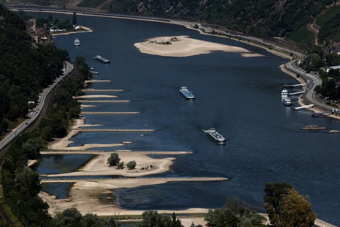 FILE PHOTO: Transport vessels cruise past the partially dried riverbed of the Rhine river in Bingen, Germany, August 9, 2022. REUTERS/Wolfgang Rattay/File Photo