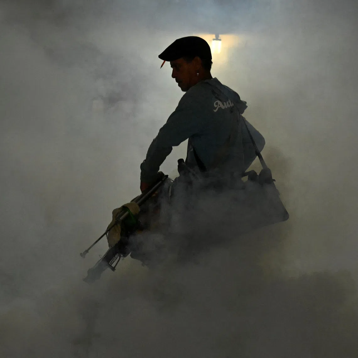 A health worker fumigates a garage with a fogging machine during a public health campaign to prevent mosquito-borne diseases, in Havana, Cuba, November 13, 2025. REUTERS/Norlys Perez