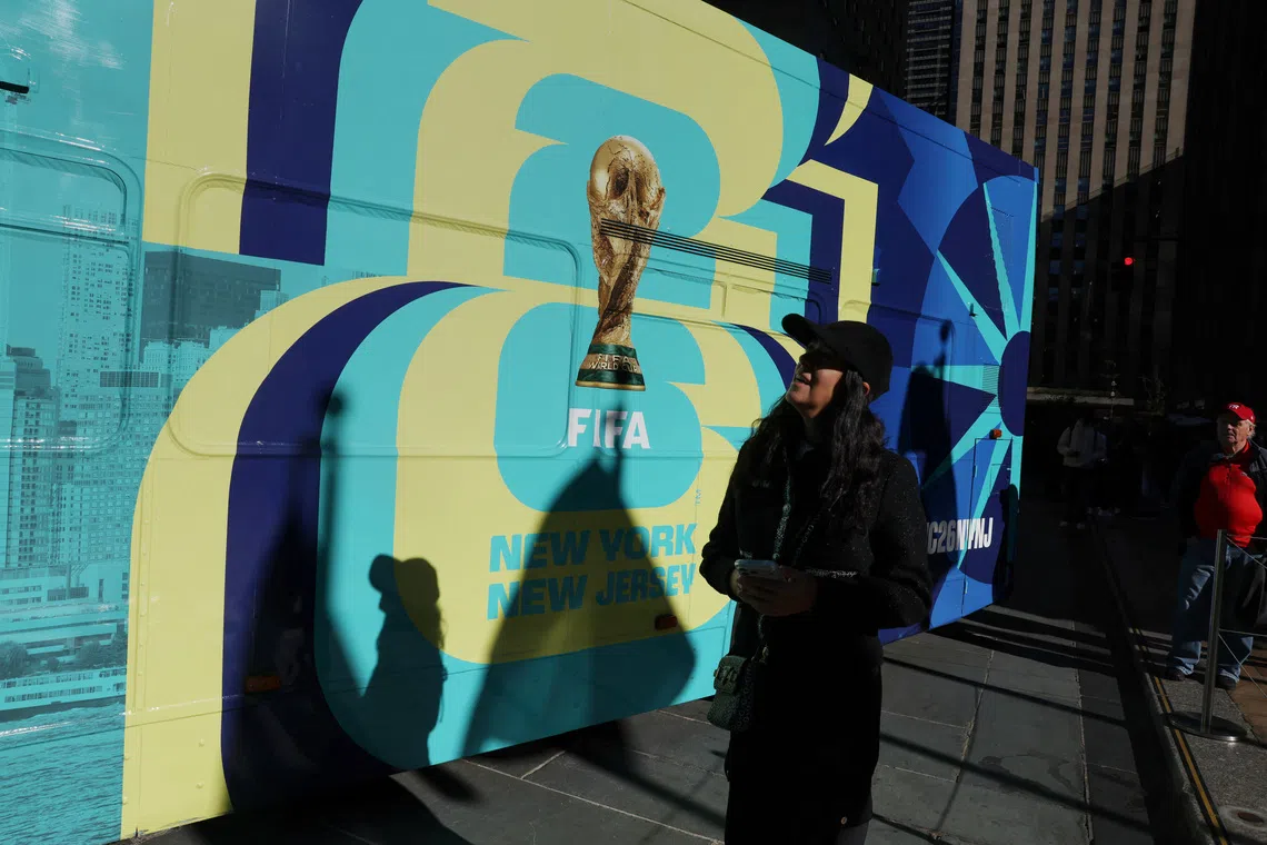A woman walks by a bus advertisement for FIFA World Cup 26 New York and New Jersey at Rockefeller Center in New York City, U.S., October 23, 2025. REUTERS/Shannon Stapleton