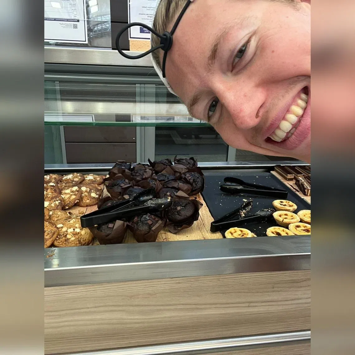 Norwegian swimmer Henrik Christiansen takes a selfie with chocolate muffins at the Olympic Village dining hall, in Paris.