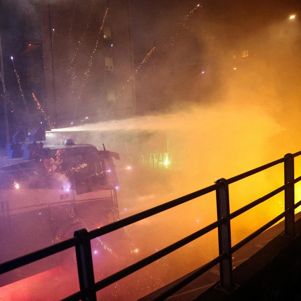 Fireworks exploding near a police water cannon used against protesters in Milan on Feb 7. Demonstrators had tried to block a road leading to the Santa Giulia Arena, in protest over the environmental, economic and social impact of the Winter Olympics.