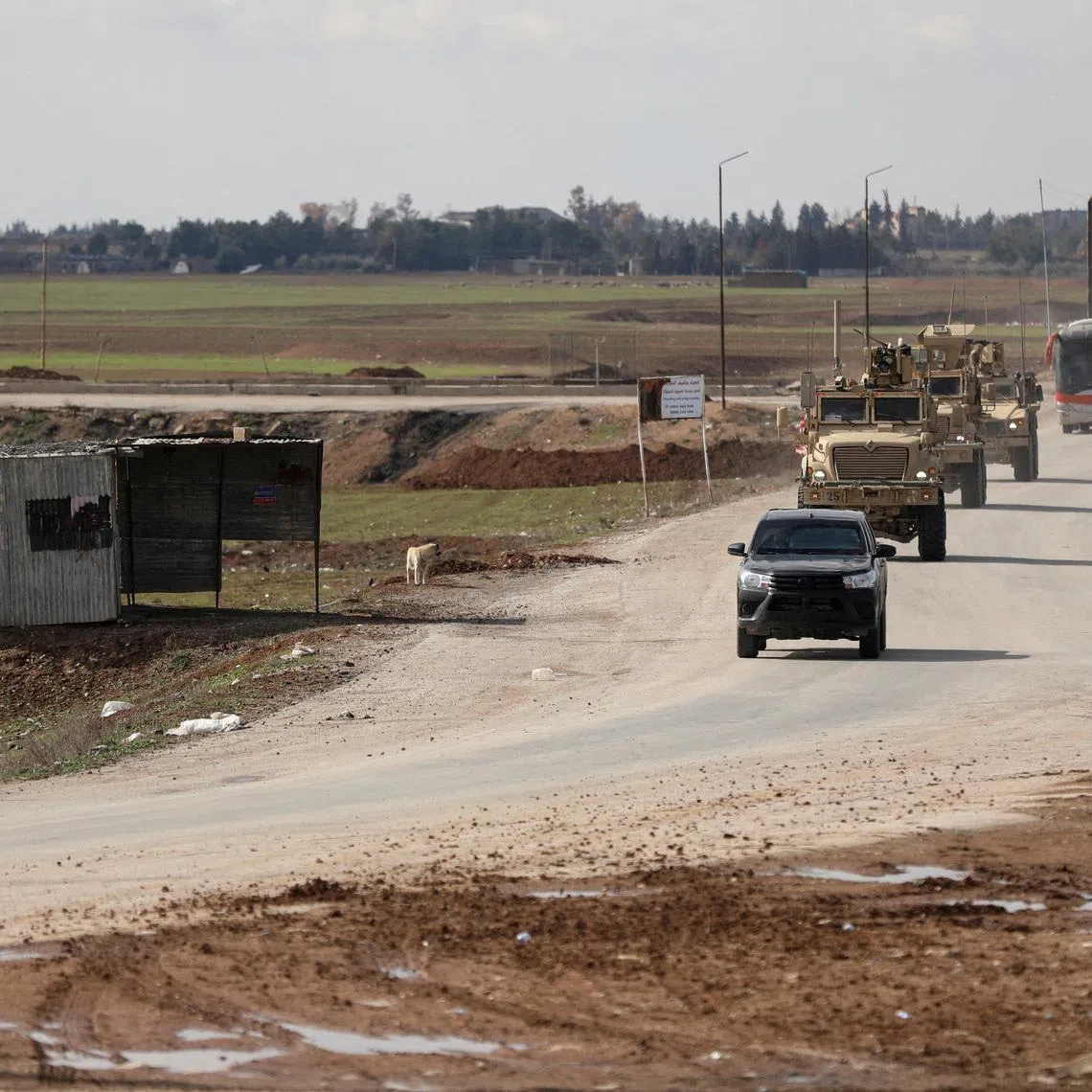 FILE PHOTO: U.S. military vehicles move ahead of buses transporting Islamic State detainees from Syria to Iraq, according to a security source from the Syrian Democratic Forces, in Qamishli, Syria, February 8, 2026. REUTERS/Orhan Qereman/File Photo