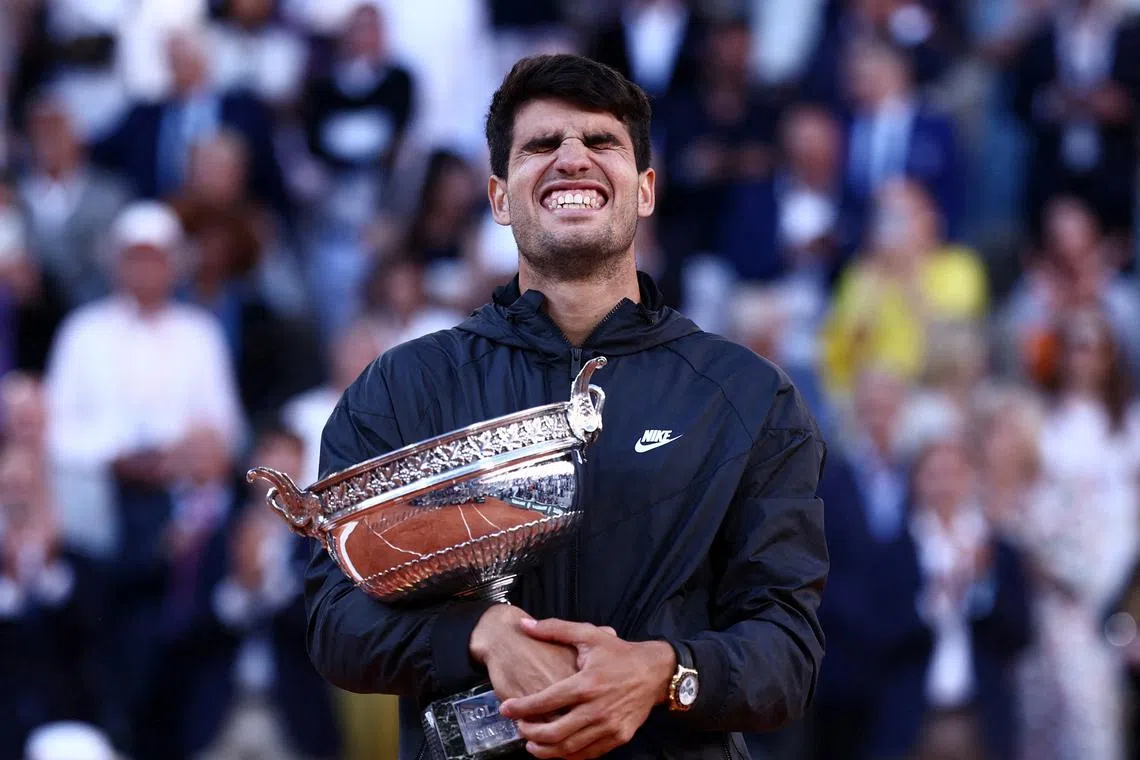Tennis - French Open - Roland Garros, Paris, France - June 9, 2024 Spain's Carlos Alcaraz celebrates with the trophy after winning the men's singles final against Germany's Alexander Zverev REUTERS/Yves Herman