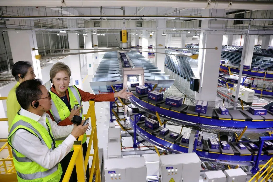 Minister for Digital Development and Information Josephine Teo, accompanied by SingPost CEO Mark Chong and chairman Teo Swee Lian, viewing the intelligent flexi sorter at the launch of SingPost's new S$30 million automated parcel sortation facility within the Regional eCommerce Logistics Hub in Greenwich Drive on June 9, 2026.