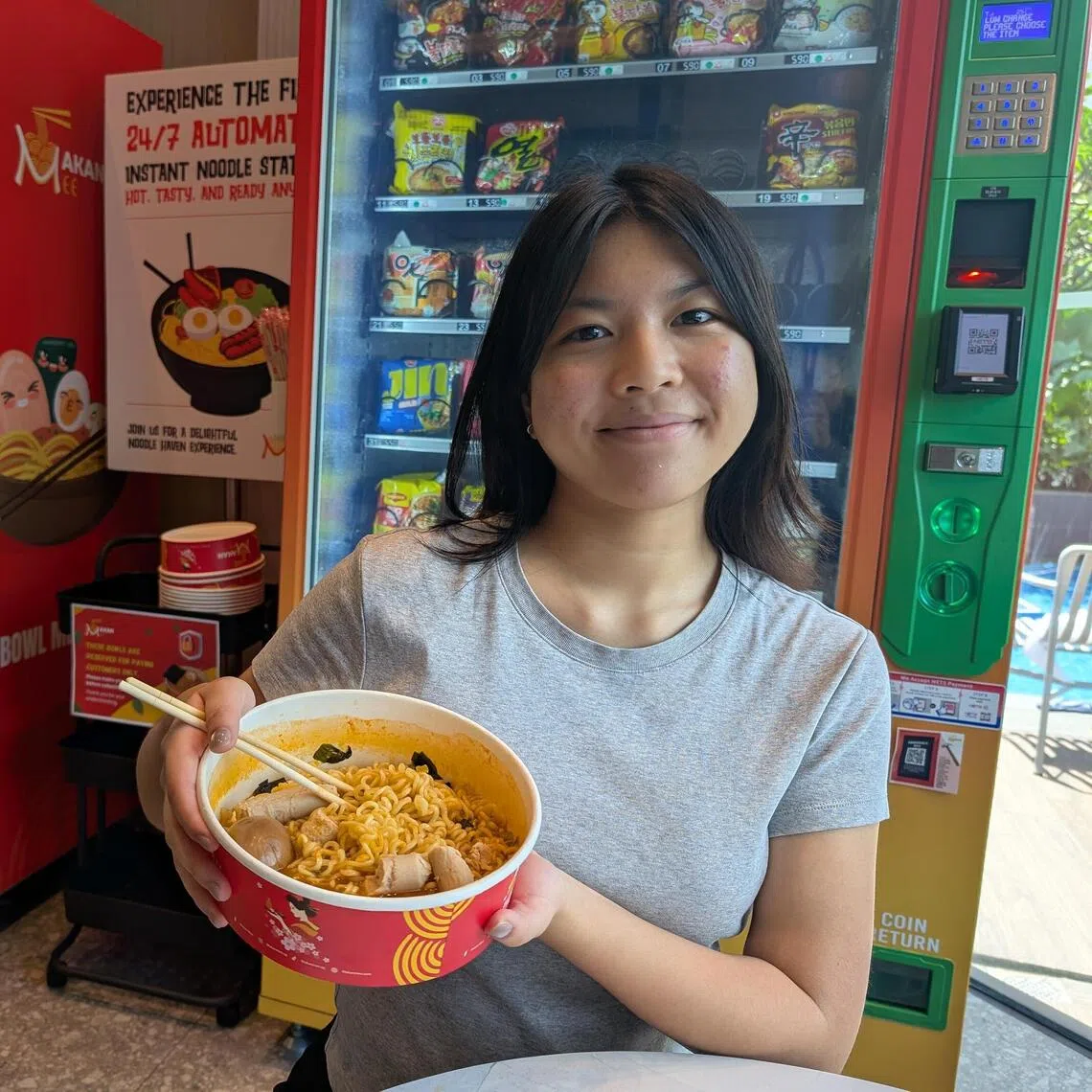 ayyramen -  Intern journalist Megan Ching with her noodles creation at Makan Mee: Shin Ramyun shrimp flavour with boiled egg and chicken sausage, coming up to a total of $10.30.

ST Photo: Ang Yiying