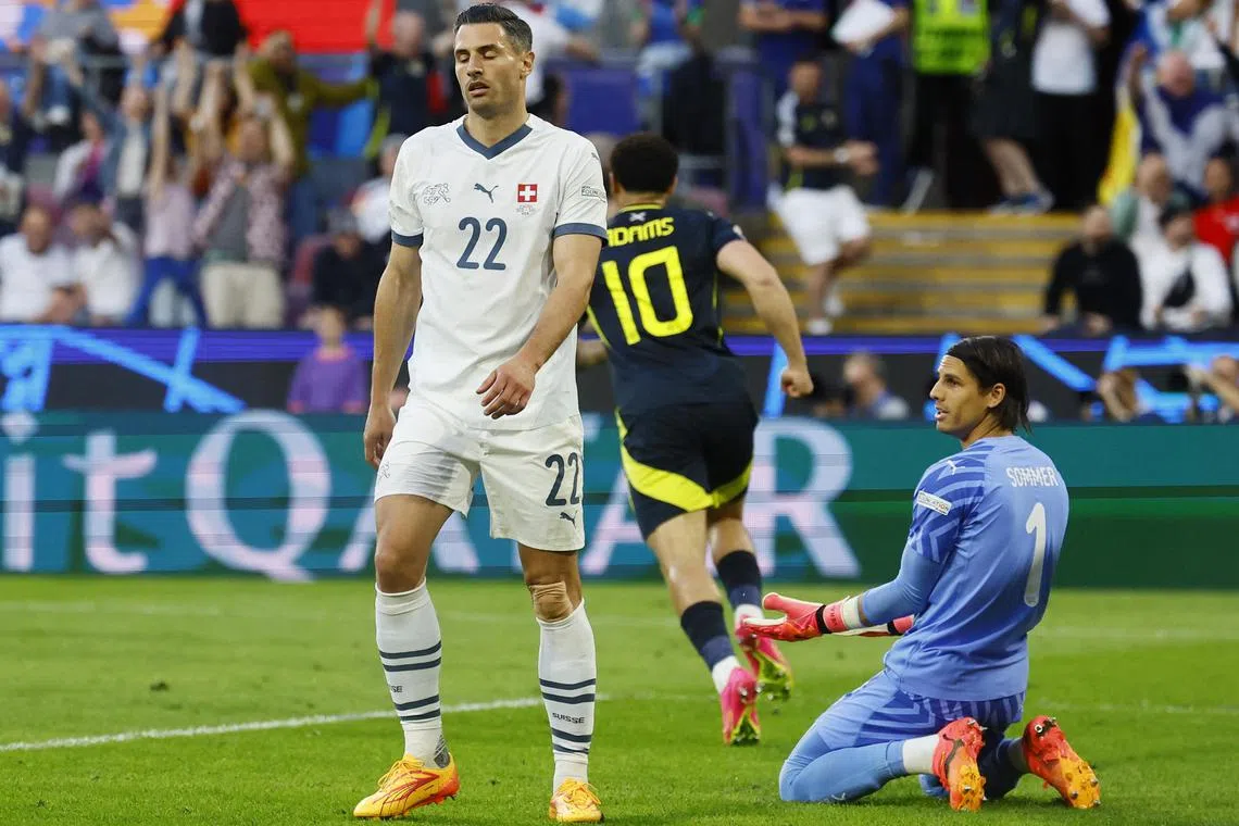 Scotland's Scott McTominay scored their first goal after a deflection off Switzerland's Fabian Schar (left).