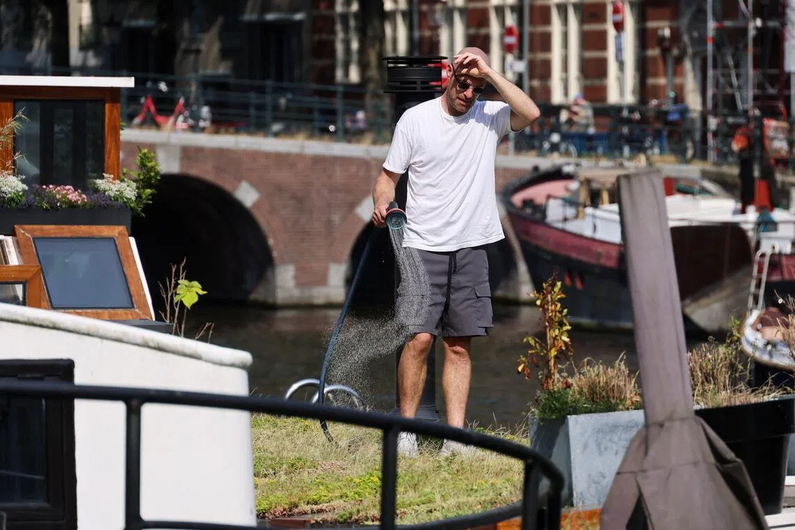 A houseboat resident watering his plants during a heatwave in Amsterdam, the Netherlands, on June 26.