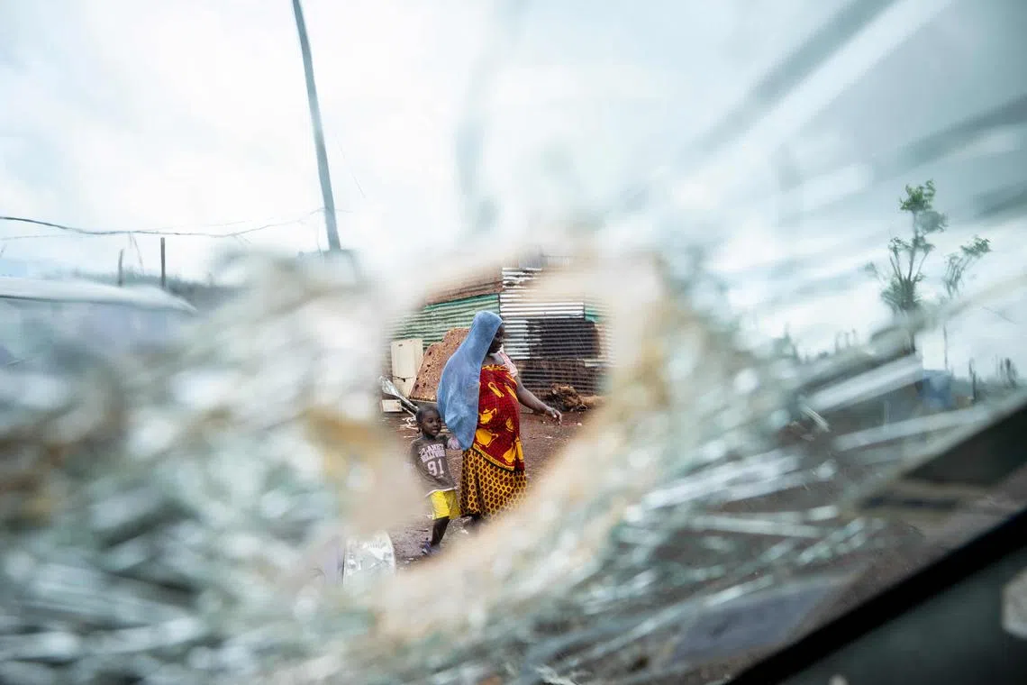 A woman with a child walks amidst destroyed houses in shanty town of Cavani south district damaged by the cyclone Chido in the city of Mamoudzou, on the French Indian Ocean territory of Mayotte, on Jan 2, 2025. 