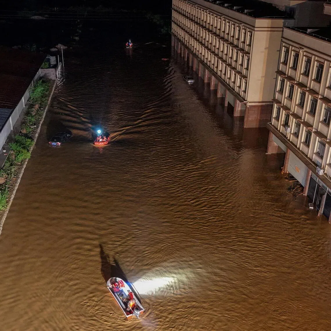 Rescue workers navigating boats through floodwaters after heavy rainfall in Hengzhou, Guangxi.