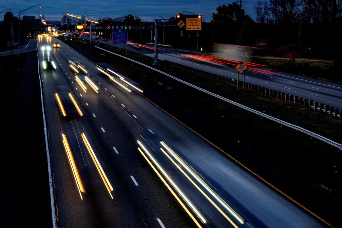 Headlights and taillights stream past as cars cross the Bay Bridge over the Chesapeake Bay in Stevensville, Maryland, on November 22, 2023 ahead of the Thanksgiving holiday. (Photo by Jim WATSON / AFP)