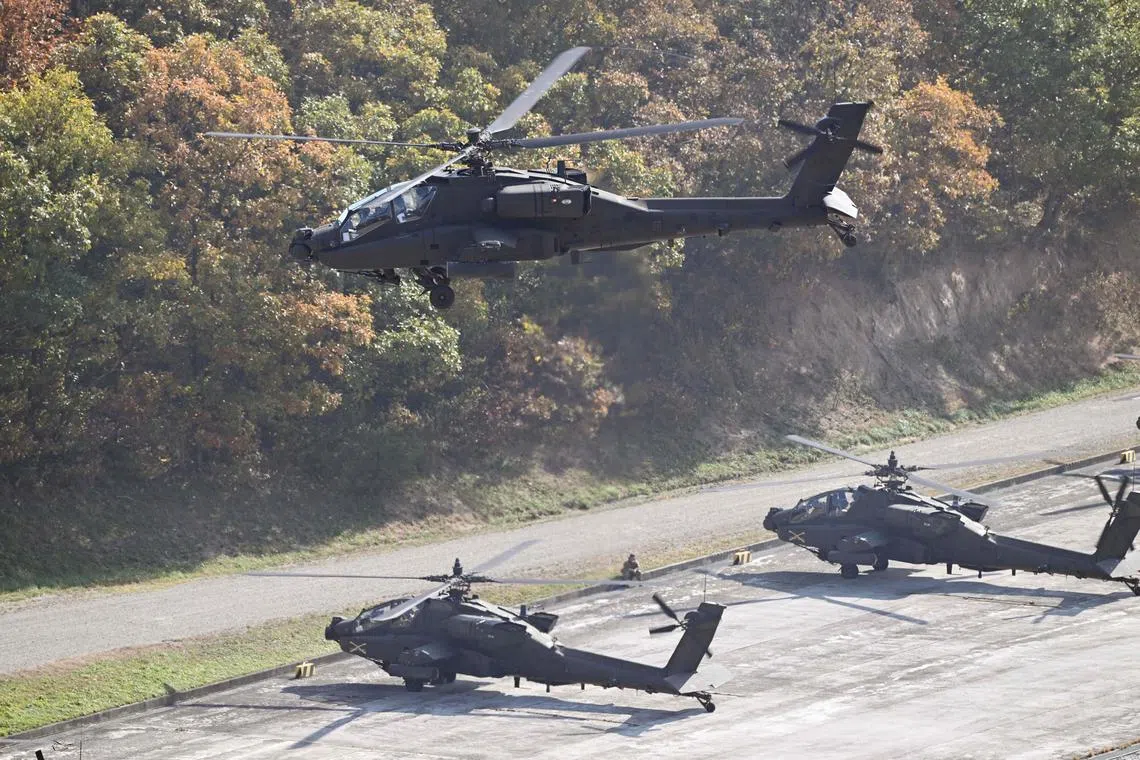 A South Korean helicopter flies over US helicopters during a combined live-fire exercise between the South Korean and US armies on Oct 30. 