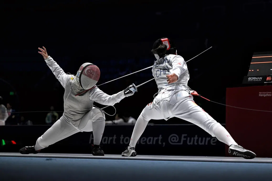 Maxine Wong of Singapore (left) in action against Huang Qianqian of China during the 19th Asian Games Women's Foil Team Quarterfinal held at the Hangzhou Dianzi University Gymnasium in Hangzhou, China on Sept 28.