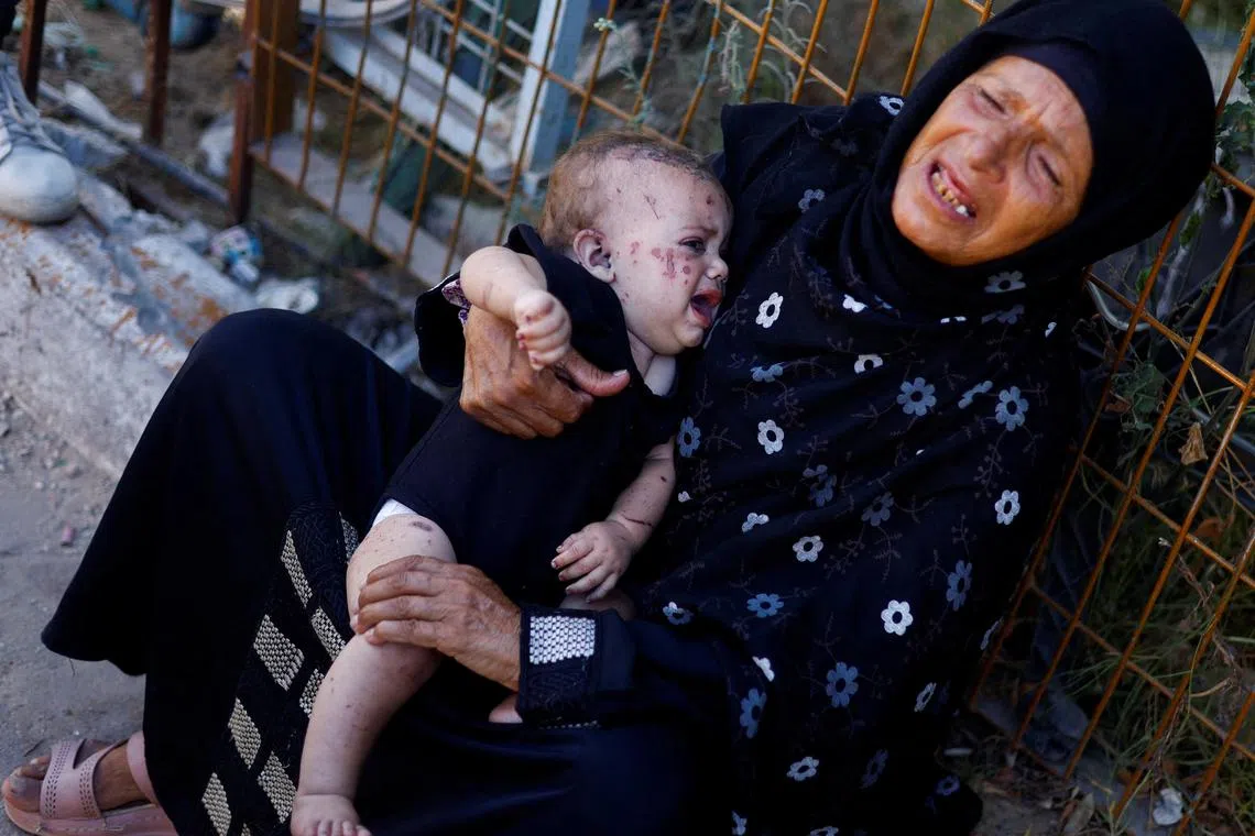 Baby Reem Abu Haya, who survived an Israeli strike that killed her entire family, cries as she is held by a relative.