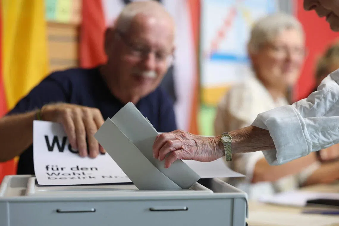 A voter casts her ballot at a polling station in Berlin during regional elections in the German capital on Sept 20.