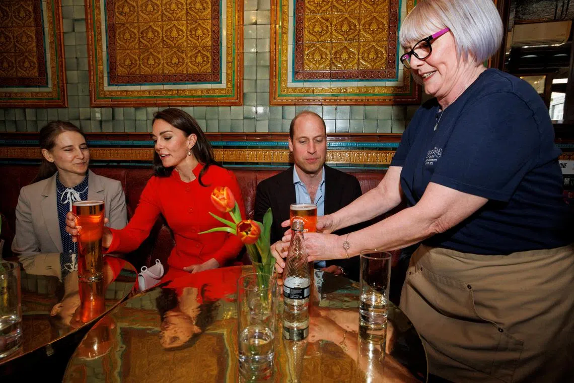 Britain's Prince William and his wife Kate, Duchess of Cambridge, are served a pint of cider by Ms Bernie Kidson inside a Soho pub.