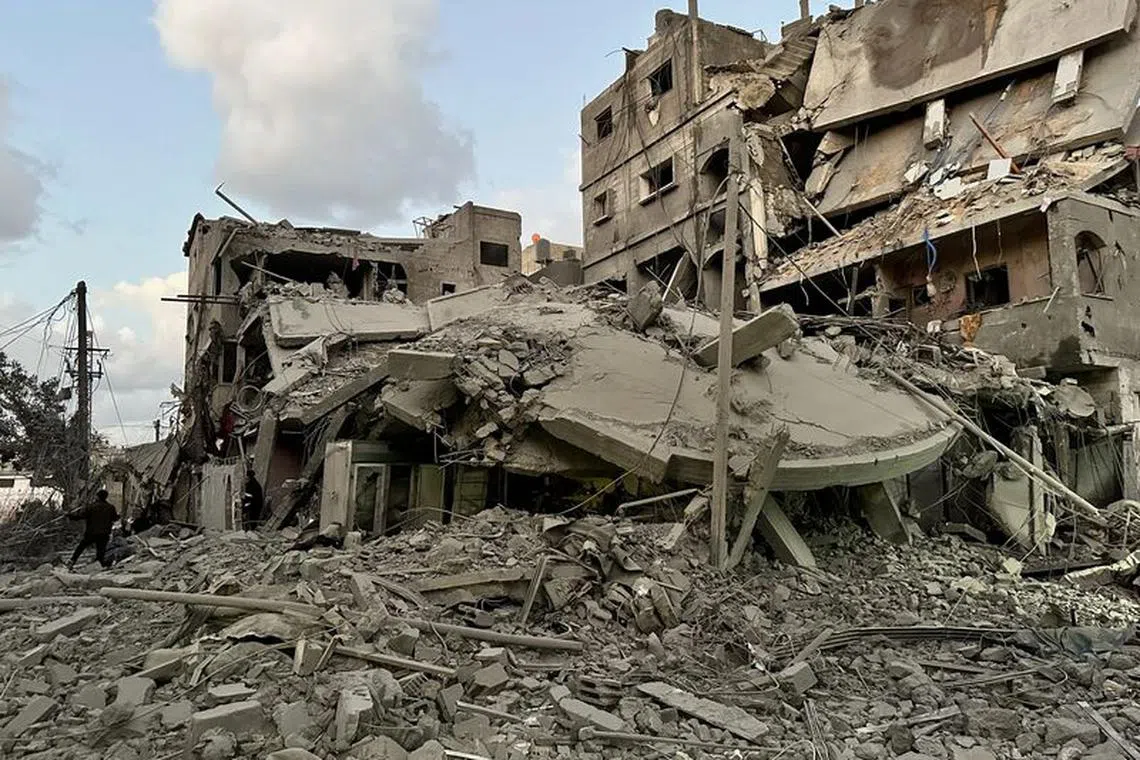 Palestinians walk at the site of Israeli strikes on houses, in Jabalia refugee camp in the northern Gaza Strip November, 21, 2023. REUTERS/Abed Sabah