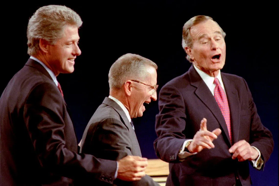 FILE PHOTO: Democratic Presidential nominee Governor Bill Clinton (L) Independent candidate Ross Perot (C) and President George Bush laugh at the conclusion of their Presidential debate in East Lansing, Michigan, U.S., October 19th, 1992. REUTERS/Mark Cardwell/File Photo