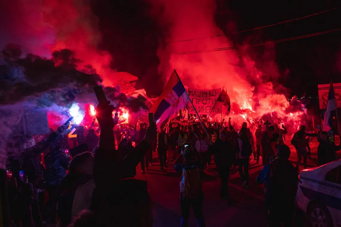 Residents light flares as they welcome hunderds of students arriving at the town of Svrljig on Feb 27, 2025, on the third day of their 130km journey to Nis, where they will join students from other cities on March 1. 