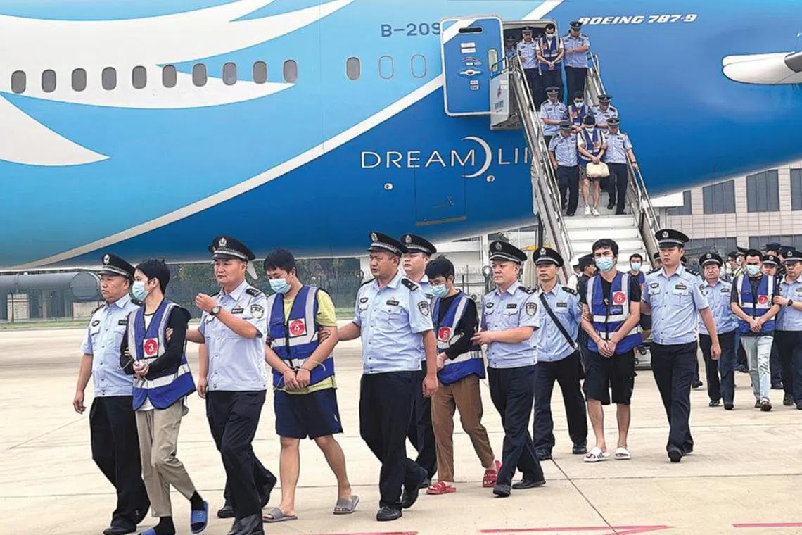 Suspects are escorted by police from a chartered civil aircraft which landed at Zhengzhou Xinzheng International Airport in Henan province on Sept 11.