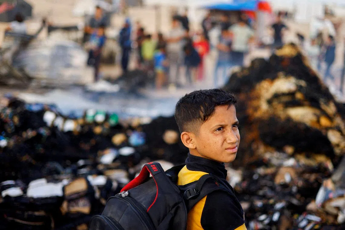 FILE PHOTO: A Palestinian boy looks on at the site of an Israeli strike on an area designated for displaced people, in Rafah in the southern Gaza Strip, May 27, 2024. REUTERS/Mohammed Salem/File Photo