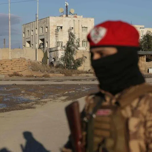 A Syrian government soldier stands outside SDF controlled Al Aktan prison which holds ISIS detainees. 