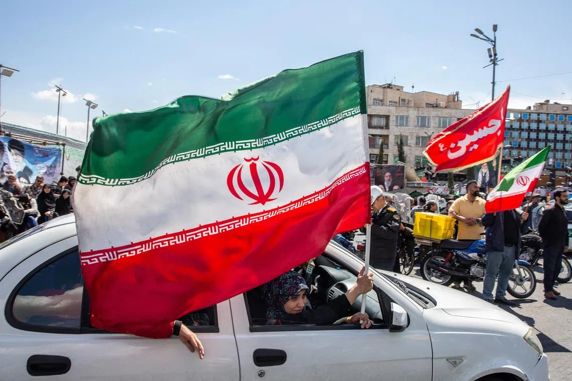 A woman waves the flag of Iran after an announcement of a two-week ceasefire in the war with the United States and Israel.