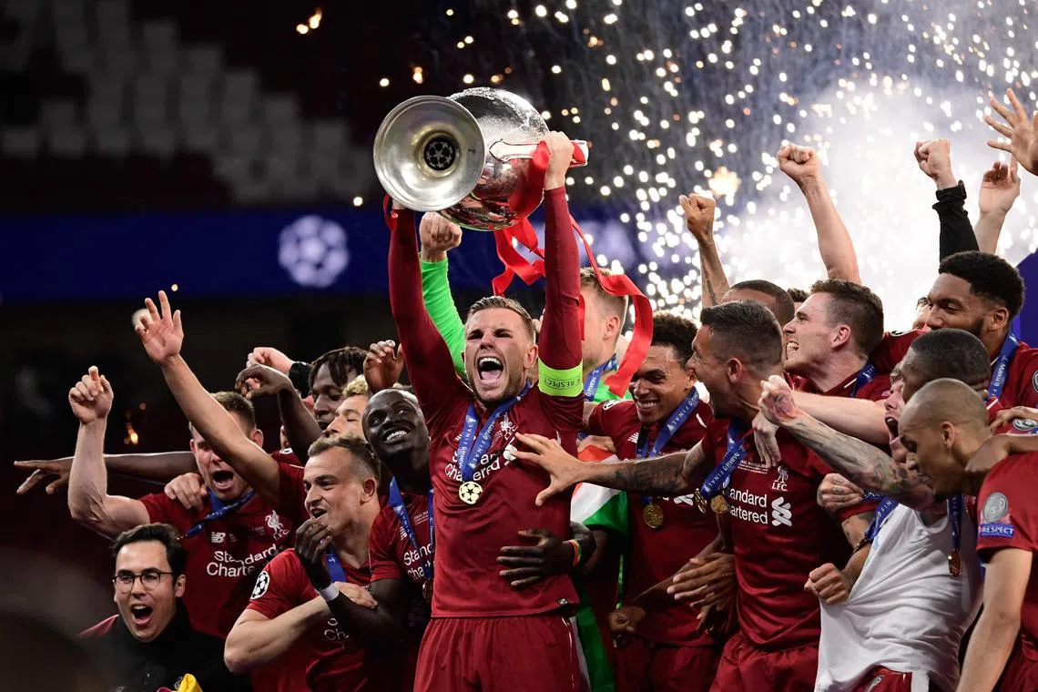 A 2019 photo shows Jordan Henderson raising the trophy after Liverpool won in the Champions League final against Tottenham Hotspur.
