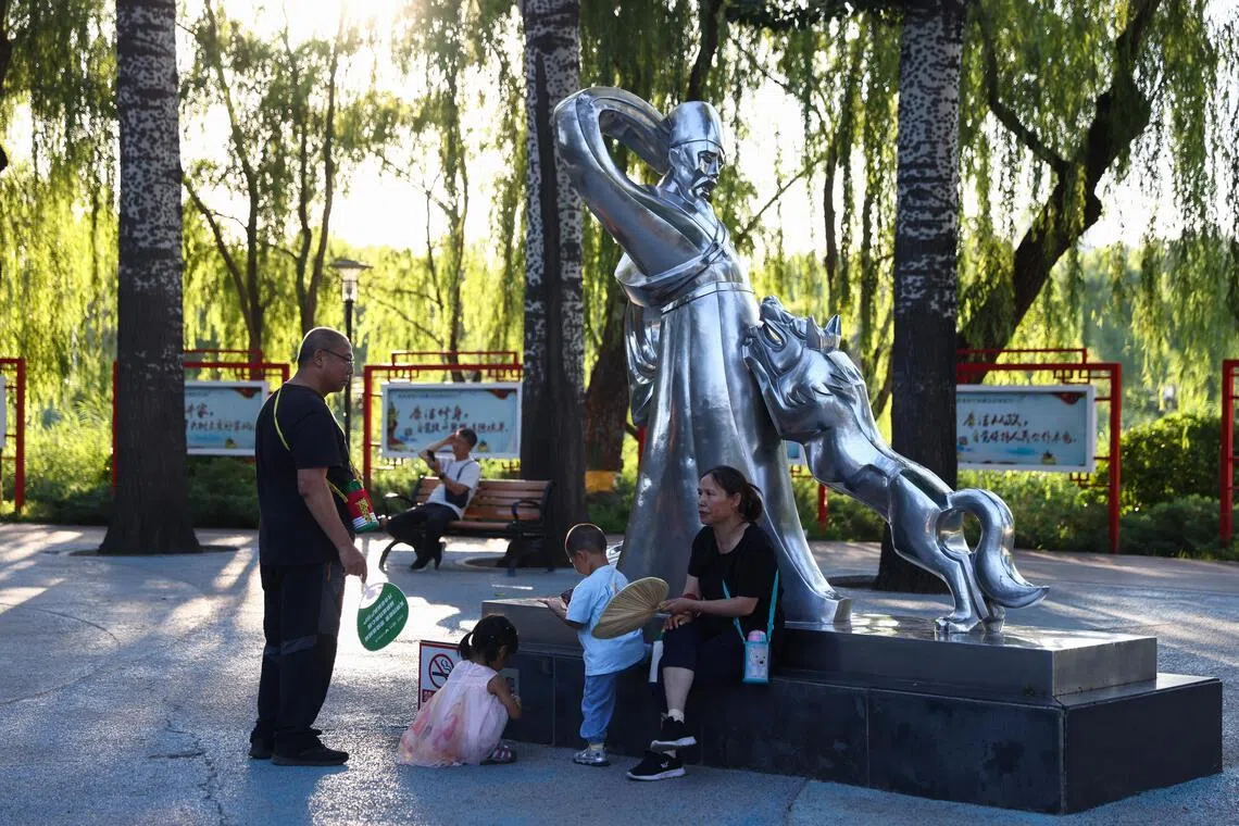 People play with children in a park in Beijing, China.
