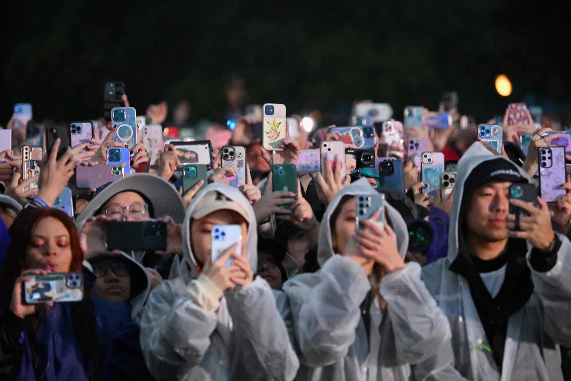Fans record with their phones as South Korean singer Jungkook performs onstage during the Global Citizen Festival at Central Park in New York City on Sept 23.