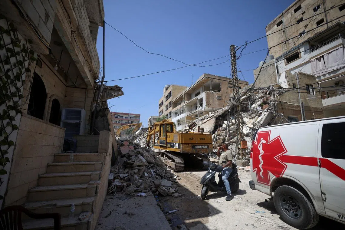A man next to an ambulance looks at the site of an Israeli strike carried out before a 10-day ceasefire between Lebanon and Israel went into effect, in Tyre, Lebanon, April 17, 2026. REUTERS/Louisa Gouliamaki