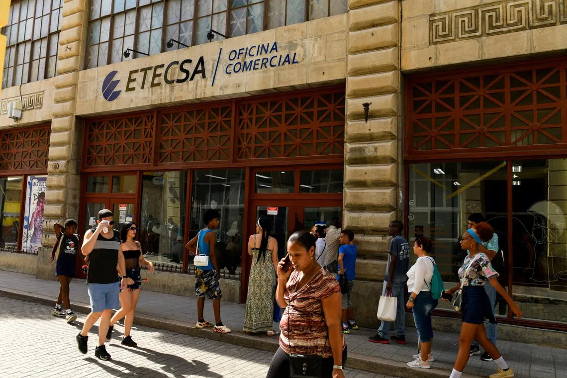 FILE PHOTO: People pass by an office of state-run telecommunications company ETECSA in Havana, Cuba June 3, 2025. REUTERS/Norlys Perez/File Photo