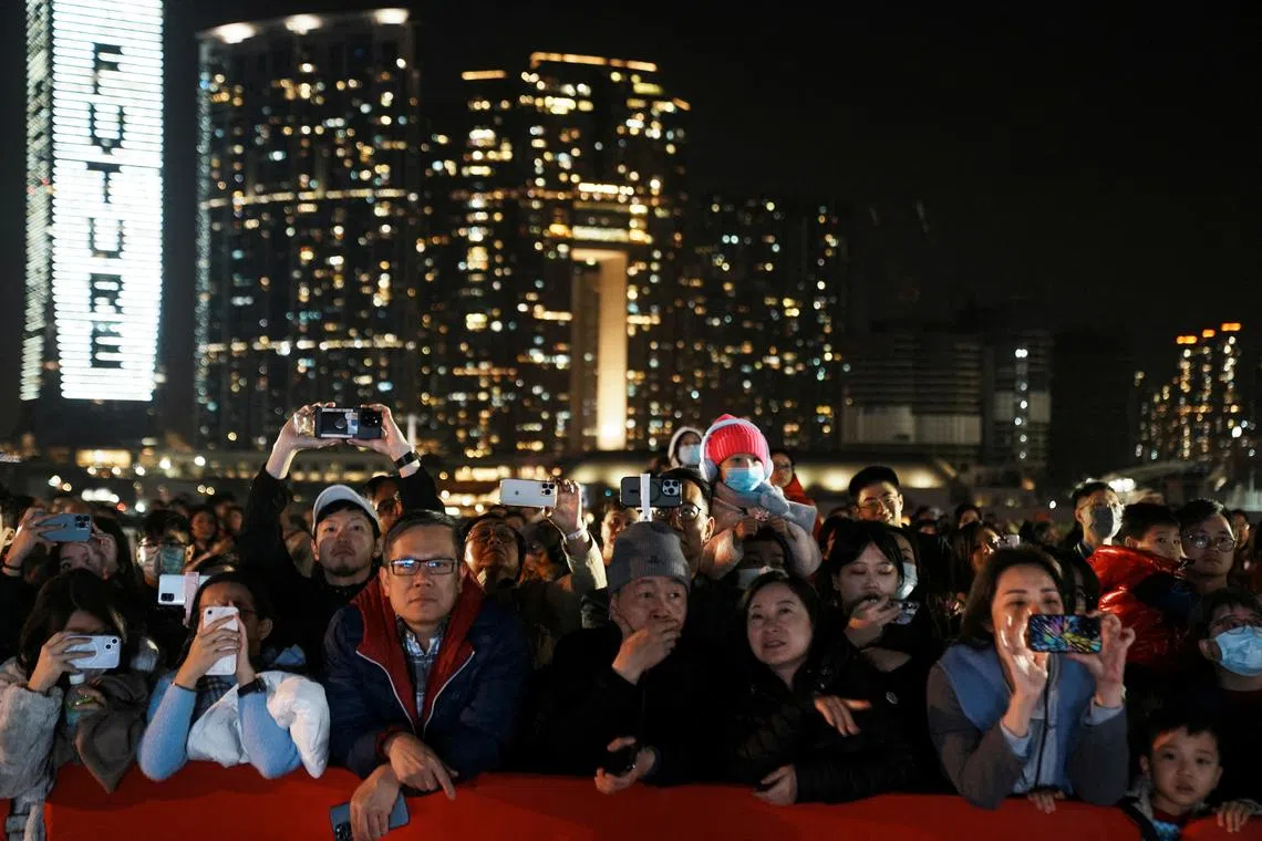 FILE PHOTO: People watch the fireworks show over the Victoria Harbour on the second day of the Lunar New Year of the Dragon, in Hong Kong, China February 11, 2024. REUTERS/Lam Yik/File Photo
