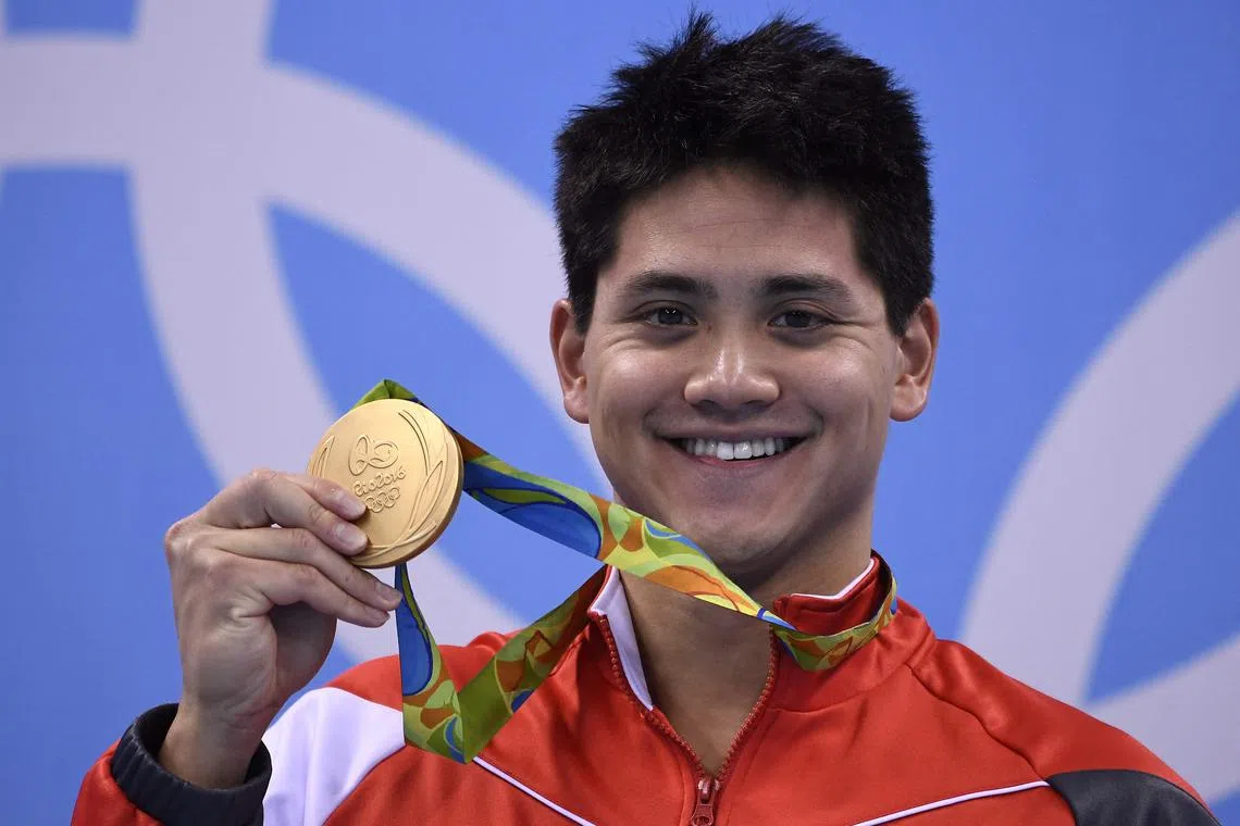 Singapore's Joseph Schooling poses with his gold medal on the podium of the Men's 100m Butterfly Final at the Rio 2016 Olympic Games.