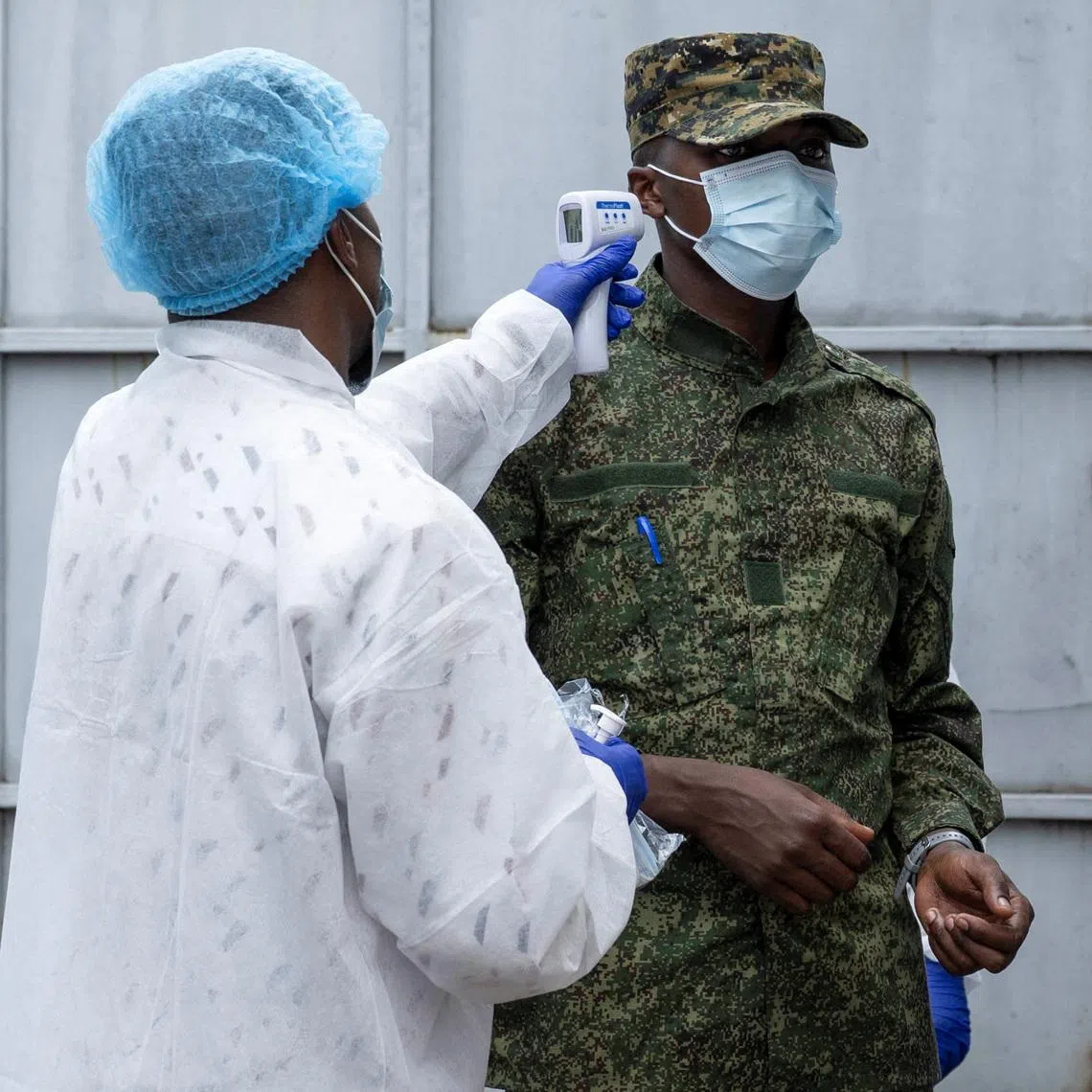 A health worker takes the temperature of an M23 rebel outside the laboratory where samples from suspected Ebola cases are examined, in Goma, Democratic Republic of Congo, May 19.  REUTERS/Arlette Bashizi