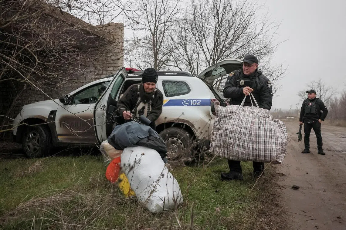 Police officers help a resident to evacuate from the front-line town of Huliaipole, in Ukraine's Zaporizhzhia region.