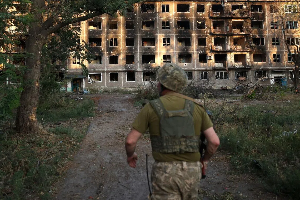A Ukrainian serviceman walking past an apartment building destroyed by artillery fire in the town of Chasiv Yar, in Ukraine's Donetsk region, on July 24.