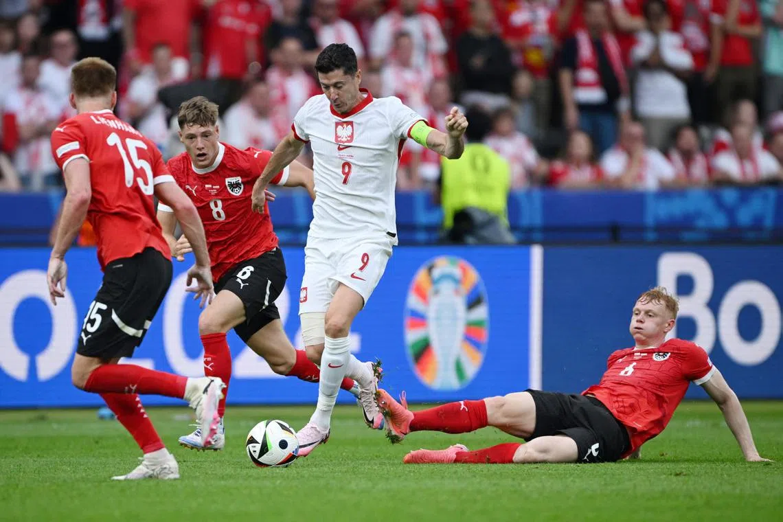 Poland's Robert Lewandowski in action with Austria's Nicolas Seiwald and Alexander Prass.