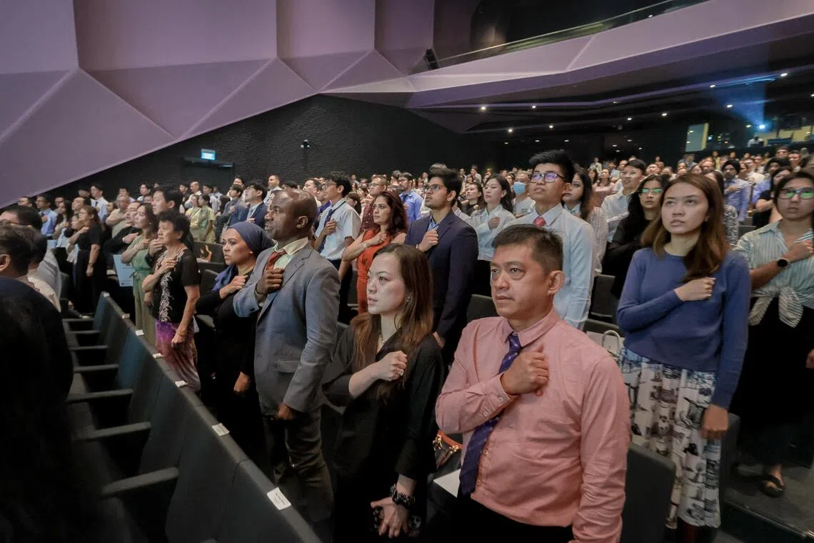New Singapore citizens recite the National Pledge during the National Citizenship Ceremony at the Singapore University of Technology and Design on Aug 15.
