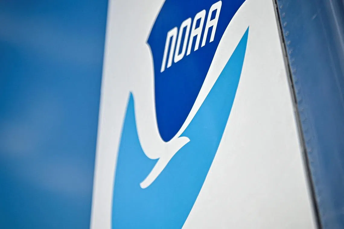 (FILES) A view of the logo National Oceanic and Atmospheric Administration  (NOAA) at NASA Kennedy Space Center in Cape Canaveral, Florida, on June 25, 2024. Hundreds of scientists and experts have been fired from the National Oceanic and Atmospheric Administration (NOAA), a leading US agency responsible for weather forecasting, climate analysis, marine conservation and more, a Democratic lawmaker said on February 27, 2025. (Photo by Miguel J. Rodriguez Carrillo / AFP)