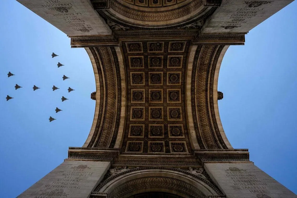 TOPSHOT - Rafale fighter jets fly over the Arc de Triomphe during a rehearsal, ahead of the Bastille Day parade on the Champs-Elysees avenue in Paris on July 9, 2026. (Photo by Dimitar DILKOFF / AFP)