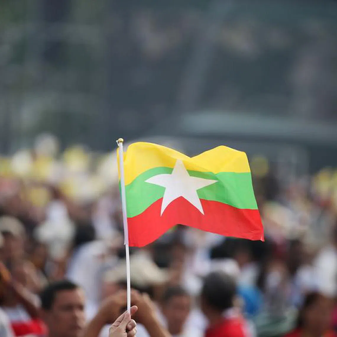 FILE PHOTO: A Catholic faithful waves a Myanmar flag as Pope Francis arrives to lead a mass at Kyite Ka San Football Stadium in Yangon, Myanmar November 29, 2017. REUTERS/Soe Zeya Tun