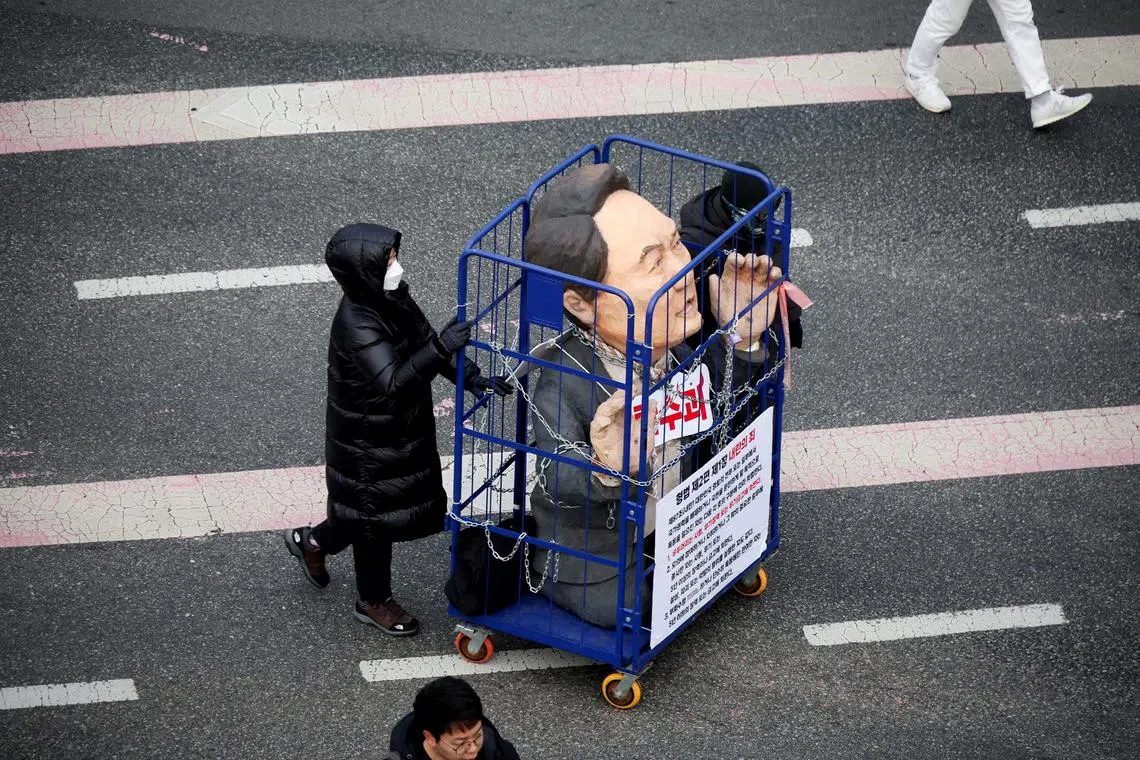A protestor pushing an effigy in a cage during a rally calling for the impeachment of South Korean President Yoon Suk Yeol, who declared martial law, which was reversed hours later, in Seoul, South Korea, on Dec 12, 2024.