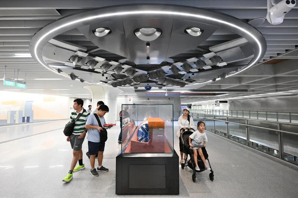 Visitors viewing an exhibition space on the concourse level of Keppel station which houses a miniature replica of a tunnel boring machine used in excavating the CCL extension on July 12.